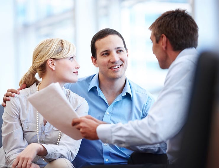 Couple meeting property manager discussing paperwork