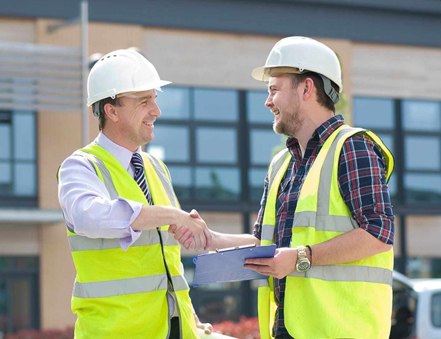 Construction workers on site shaking hands