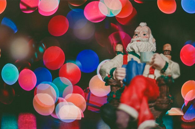 Santa toy in front of Christmas lights