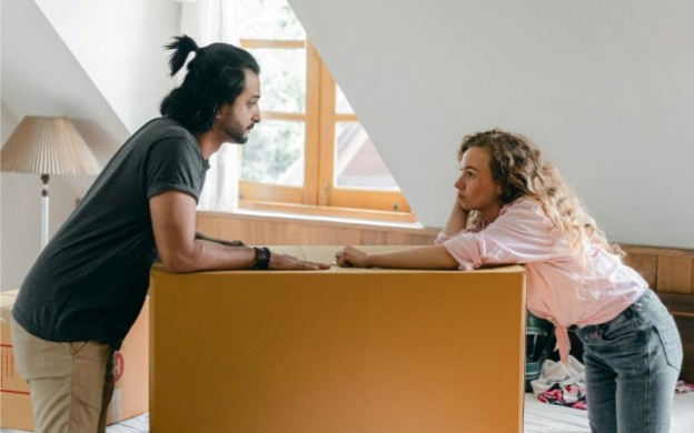 Couple leaning on moving box