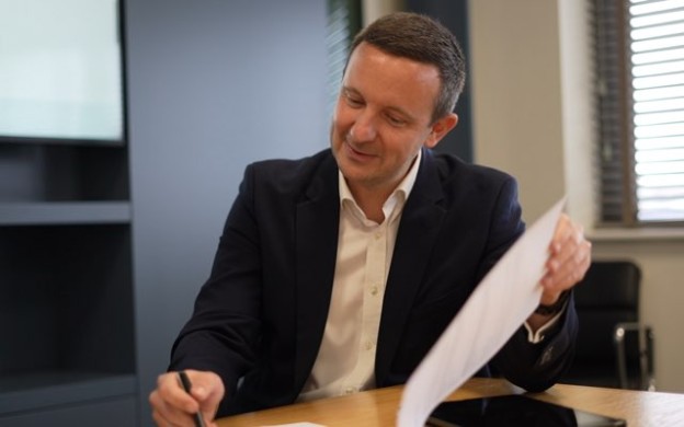 Sales, Lettings and Mortgage Advisor signing paper