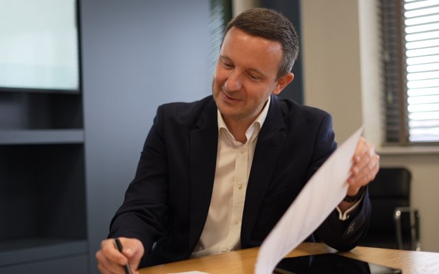 Sales, Lettings and Mortgage Advisor signing paper